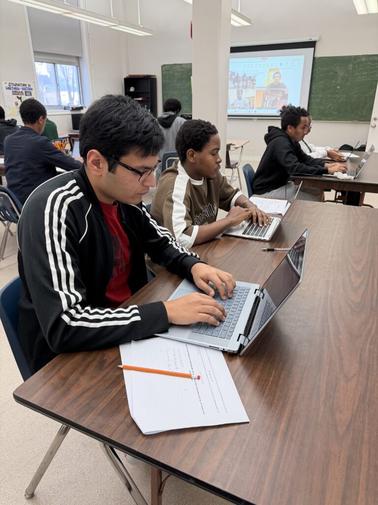 GLCT students learning with laptops and digital tools.